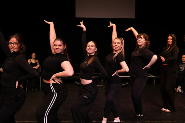 A group of performance students stood in a pose