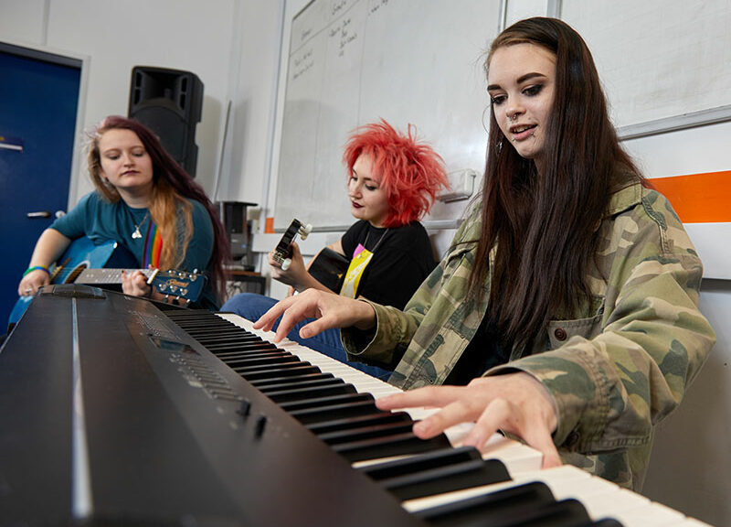Three students playing musical instruments