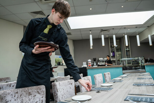 A student laying a table at The Wharncliffe