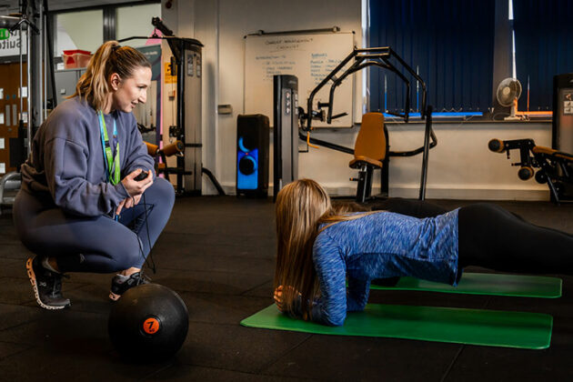 A student being timed doing a plank in the gym