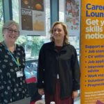 Careers staff stood next to a Careers Lounge banner