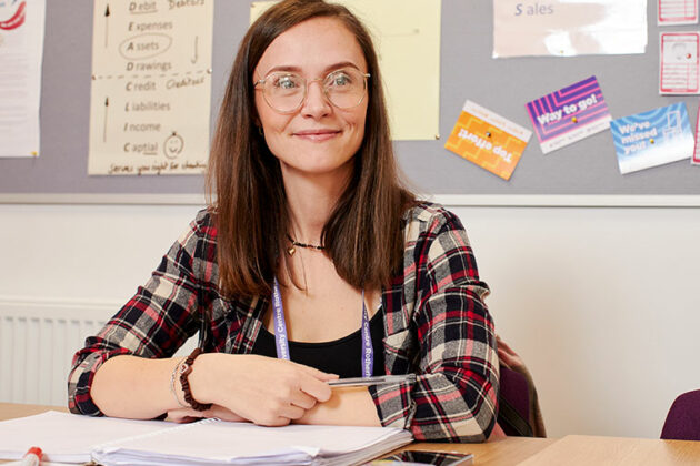 An adult learner sat at a table with open books in front of them
